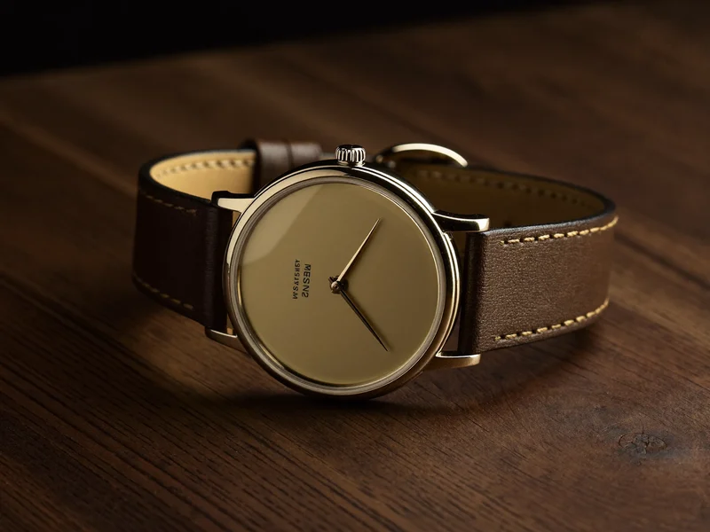 Orologio automatico dal quadrante semplice e cinturino in pelle su legno di noce