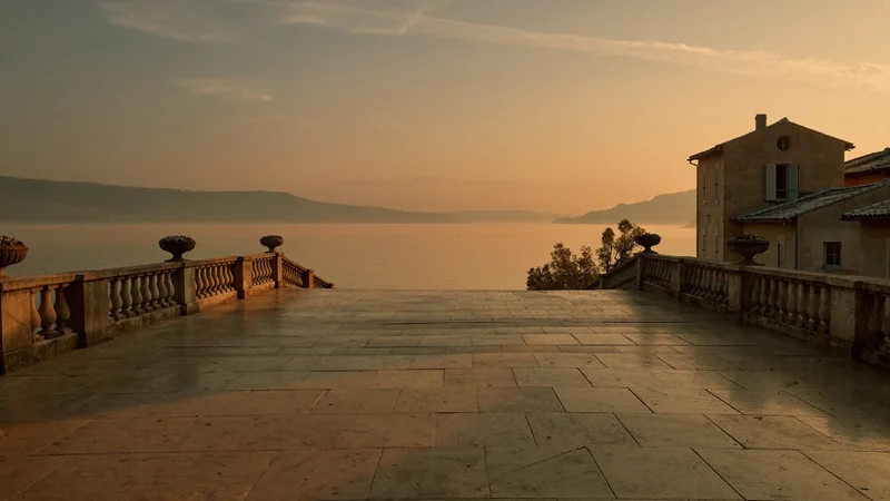 Passeggiata sul lago al tramonto con edifici in pietra sullo sfondo